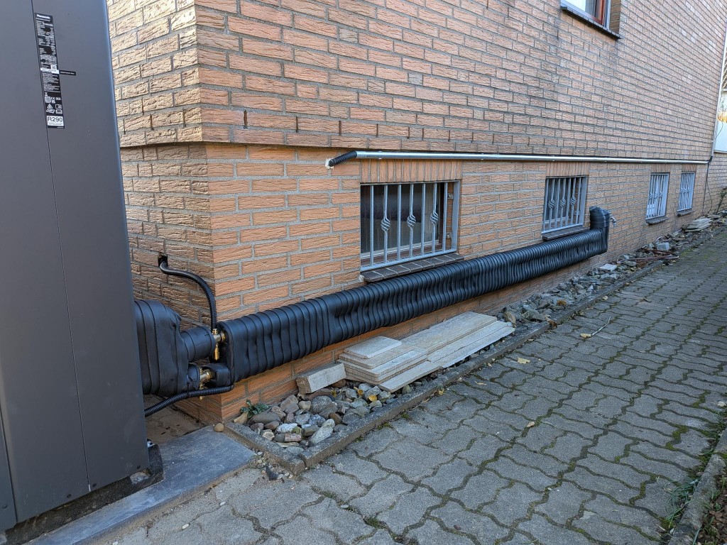 Wärmepumpe Referenz – gedämmte Leitungen und Elektroinstallation an der Hauswand